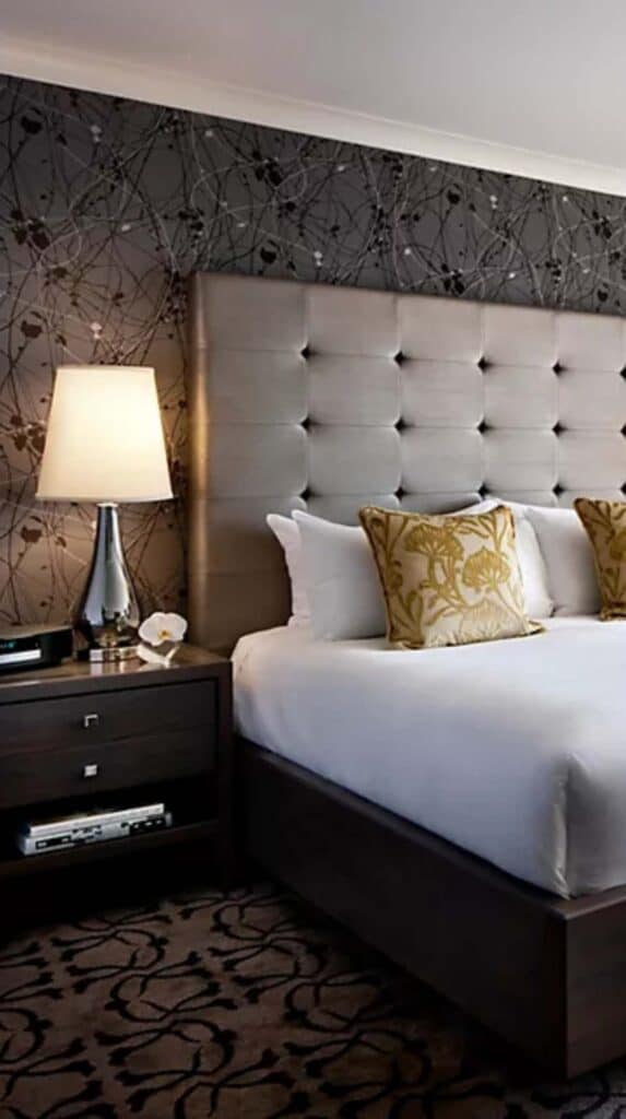 legant hotel room with upholstered headboard and bedside lamp at a Vancouver cruise port hotel.