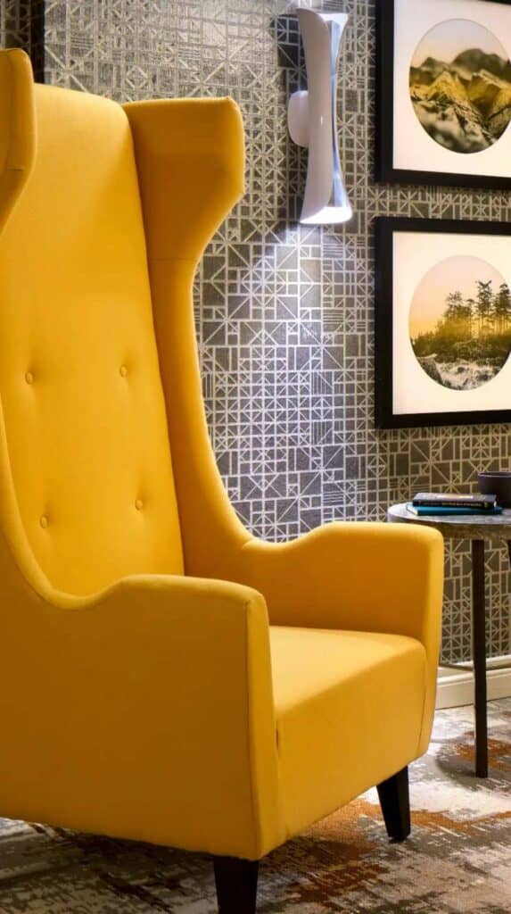 Yellow armchair beside table and framed art in a Vancouver hotel room near the cruise port.