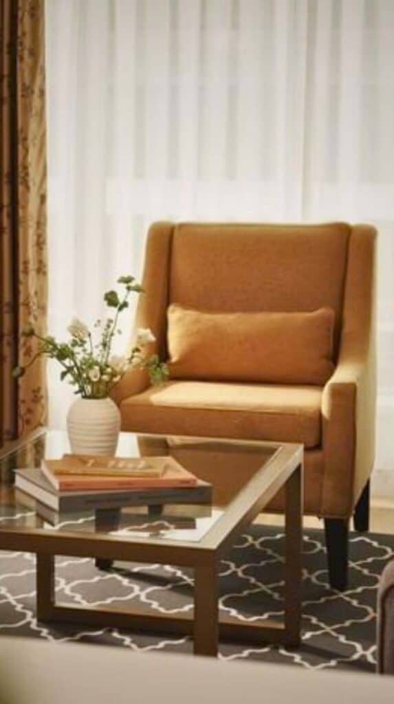 Cozy seating area with armchair, coffee table, and soft lighting in a Vancouver boutique hotel suite.