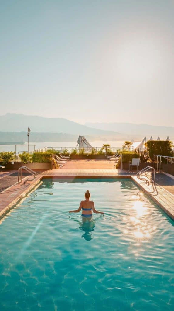 Outdoor pool overlooking Vancouver harbor with mountains in the distance at a cruise port hotel.