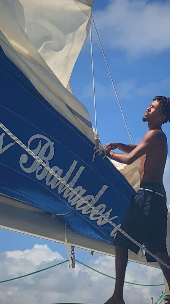Crew member adjusting the sail on a catamaran excursion booked through where to stay in Martinique hotels