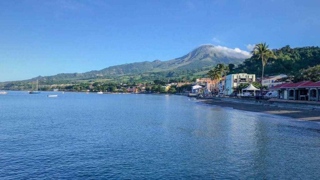 Le Carbet waterfront with Mount Pelée rising behind vacation rentals in Martinique on the western coast