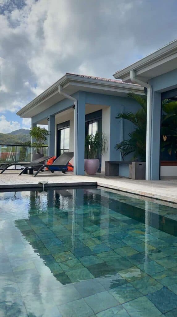 Private villa pool with glass walls open to a hillside patio at one of the best vacation rentals in Martinique