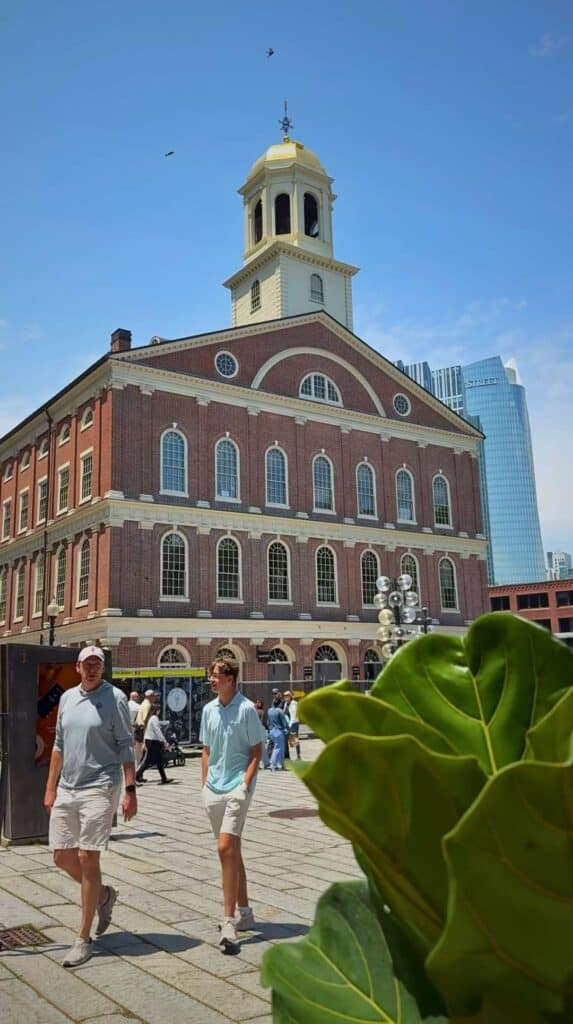 Visitors walk the Freedom Trail past Faneuil Hall in downtown Boston

