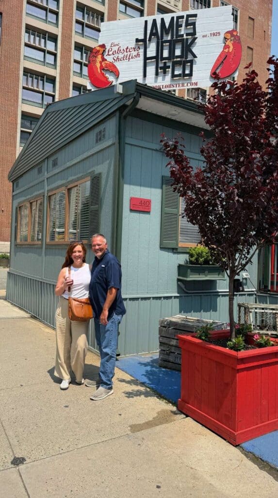 Group photo outside the small green James Hook and Co lobster shack in Boston
