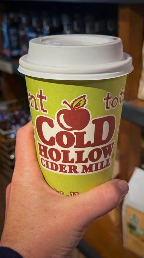 Holding a hot cider from Cold Hollow Cider Mill on a crisp fall day
