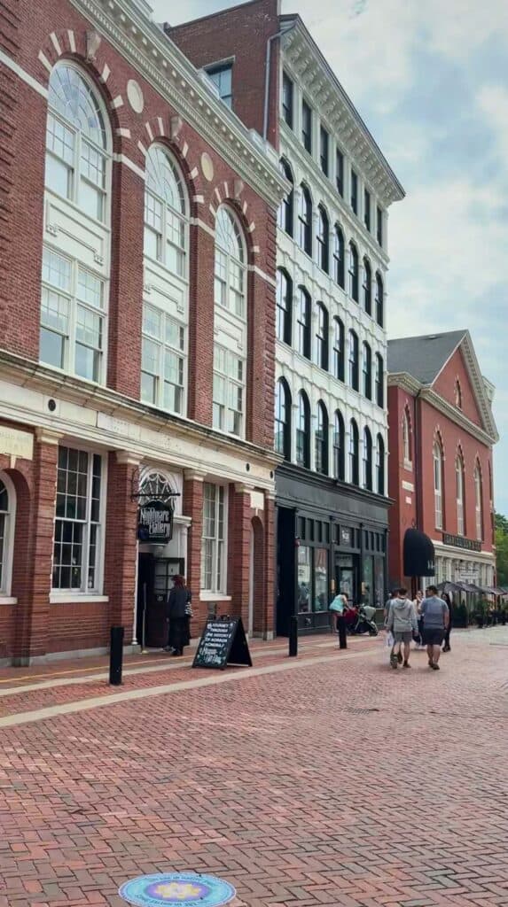 Red brick storefronts line a cobblestone street in Salem, Massachusetts

