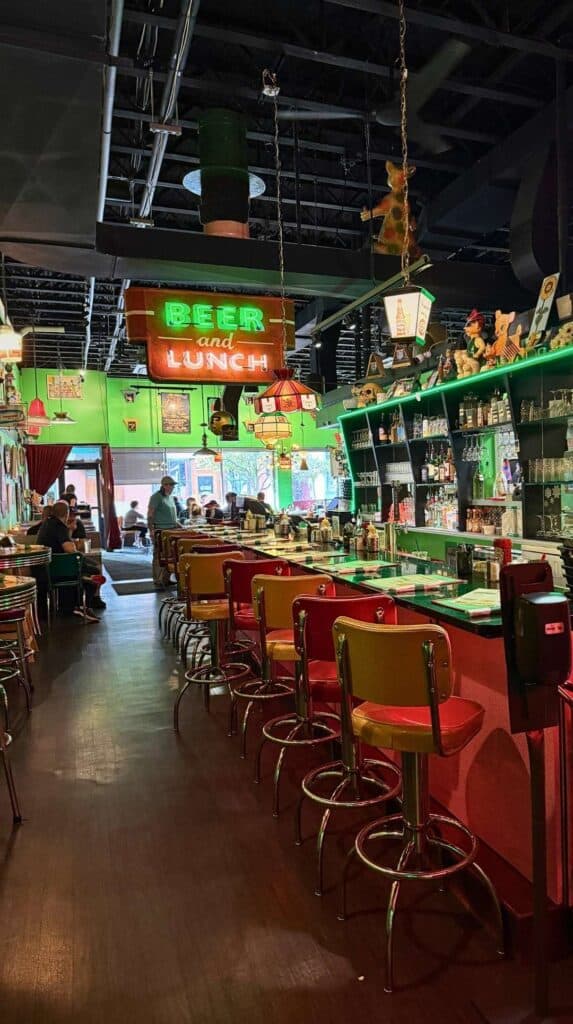 A neon sign and cozy bar seating inside a Portsmouth restaurant
