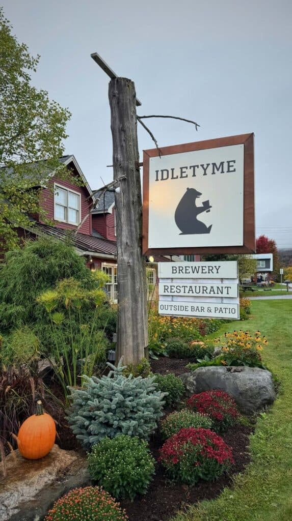 The Idletyme Brewery and Restaurant sign lit up in the evening in Stowe
