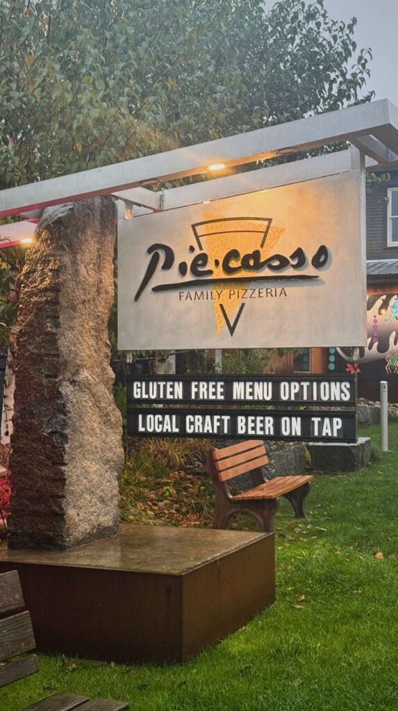 The Piecasso Family Pizzeria sign sits along a rainy Stowe street

