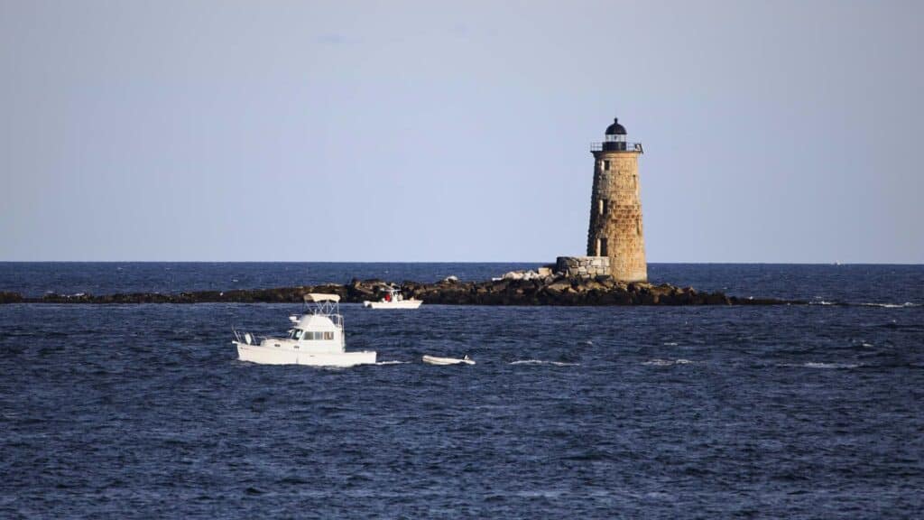 Whaleback Lighthouse rises from a rocky ledge off the coast of Portsmouth
