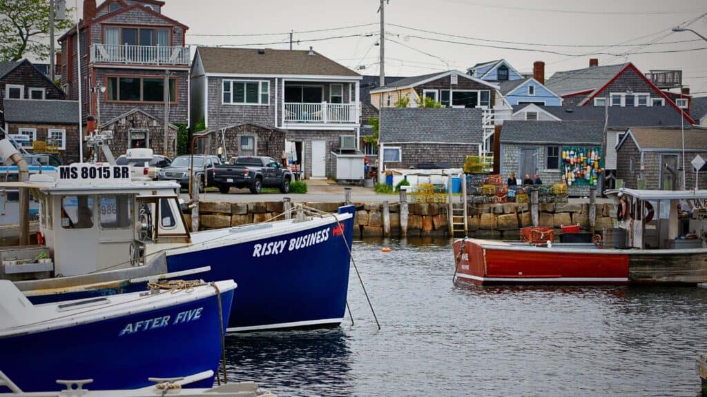 Fishing boats including one named Risky Business dock in a Rockport harbor
