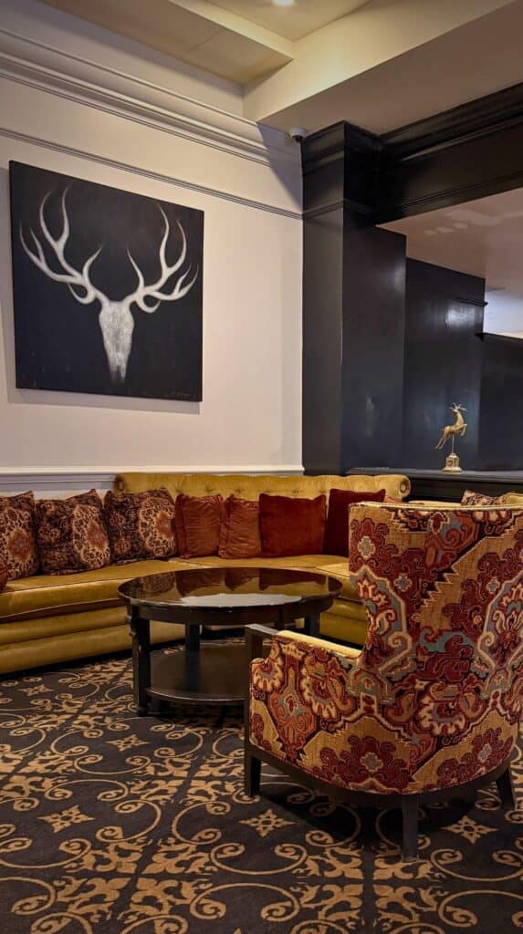 Gold curved sofa and antler-inspired art in the lobby of one of the themed hotels Colorado Springs features.
