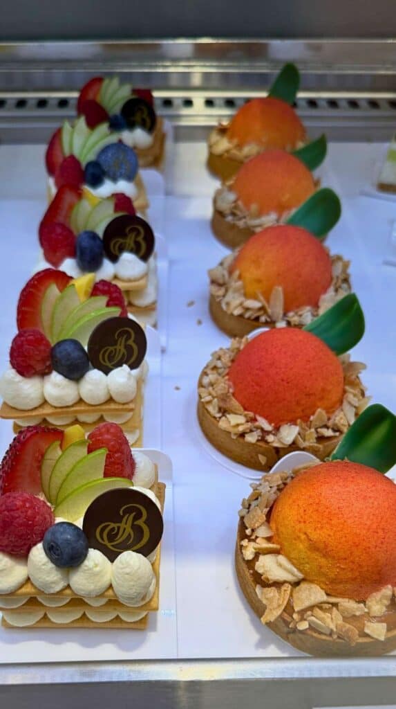 Rows of berry tarts and almond peach pastries in the case at Cafe Julie's