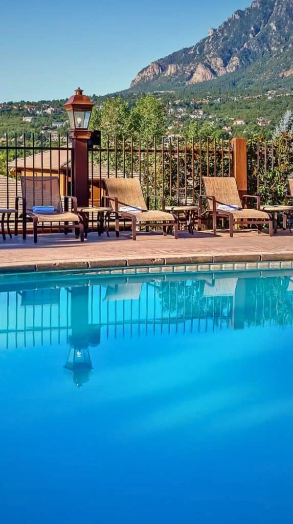 Outdoor pool lined with wooden loungers at one of the romantic hotels Colorado Springs couples book.
