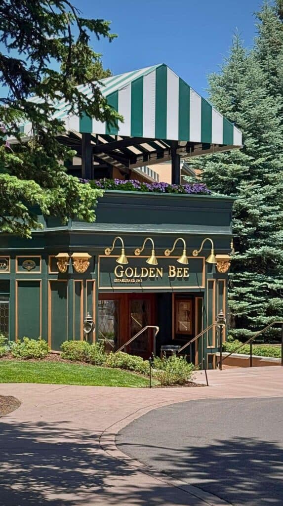 The green-and-white striped awning and gas lamps outside the Broadmoor Golden Bee English pub
