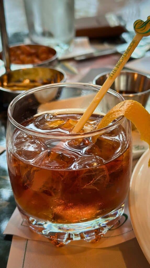 An old fashioned with a branded Broadmoor stir stick and orange peel at the Hotel Bar