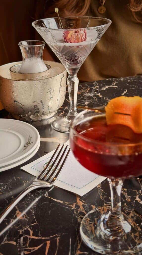 A rose-garnished martini and a negroni on black marble at the Hotel Bar