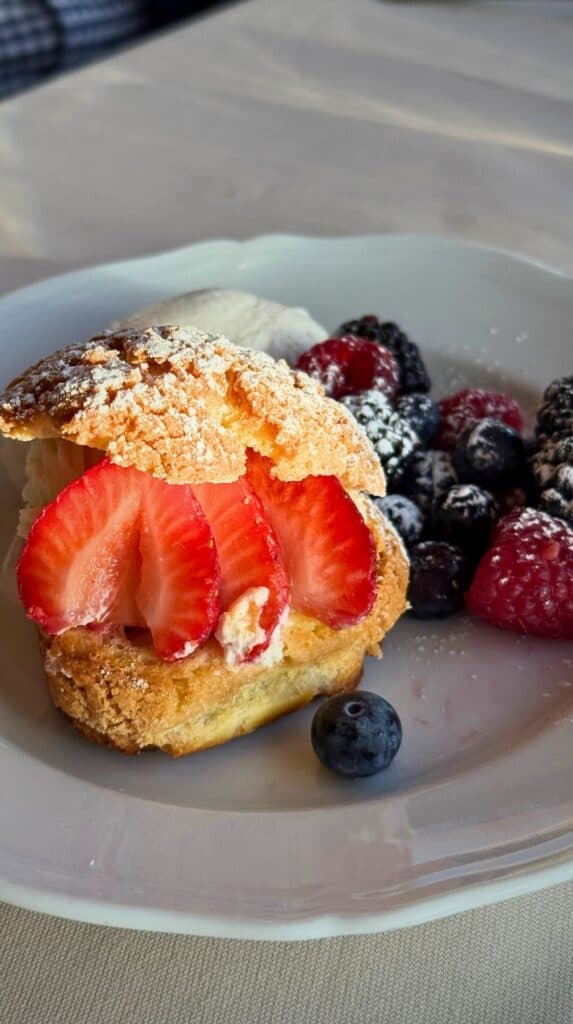 Choux pastry with cream, strawberries, and berries, a sweet moment from our Broadmoor hotel dining tour