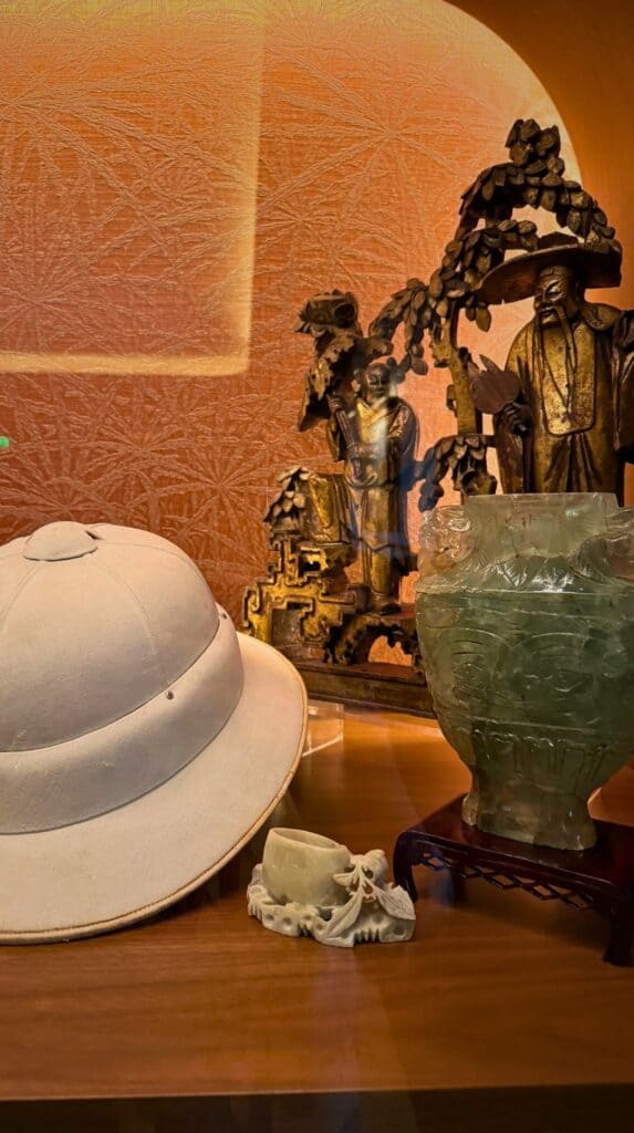 Display case of the Penroses' pith helmet and jade vases outside the Penrose Room dining room