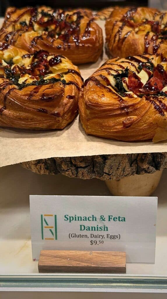 Spinach and feta danishes above their price card at the Natural Epicurean