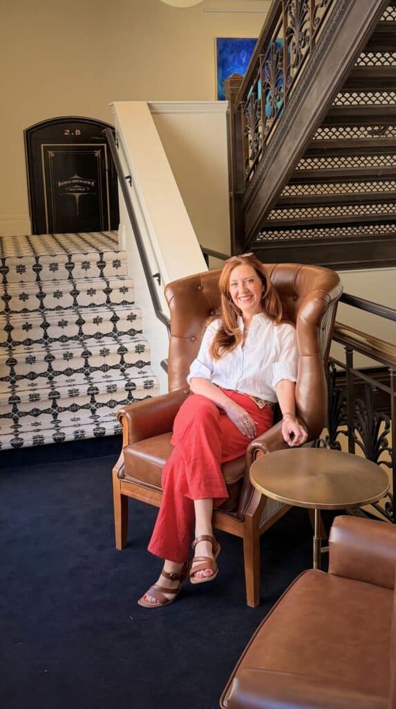A leather wingback chair by a patterned staircase wall, one of the boutique hotels Colorado Springs is known for.
