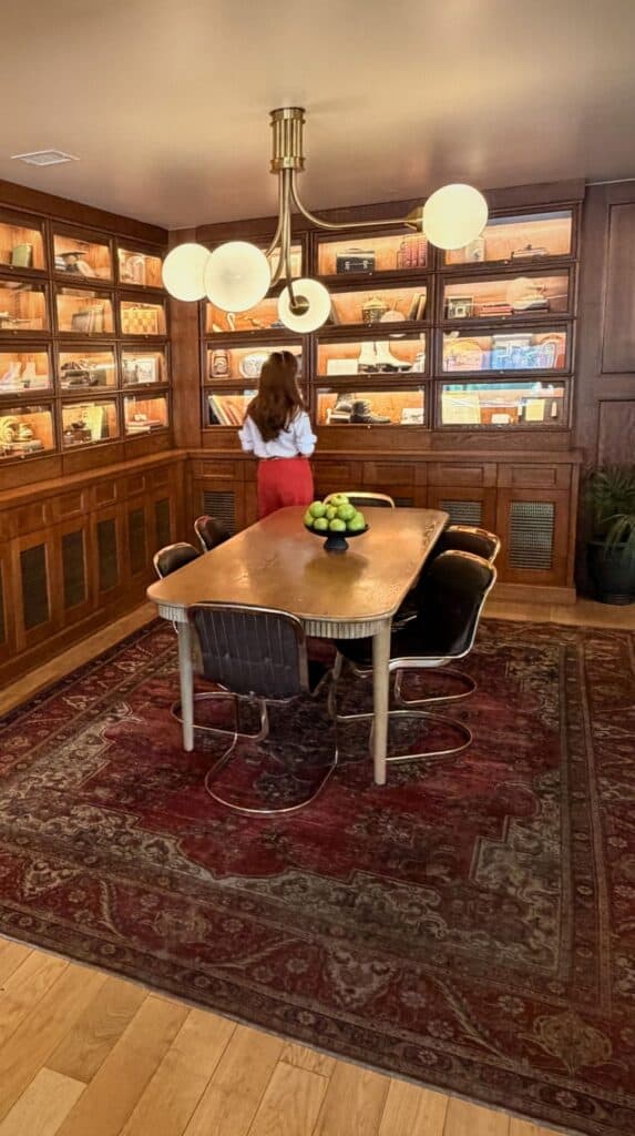 Unique hotels in Colorado Springs showing a wood-paneled lounge, retro copper table and a bowl of green apples.
